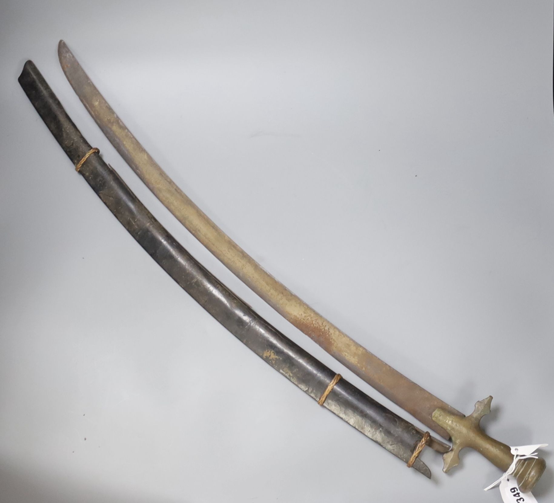 An Indonesian sword with brass handle, 19th century, blade stamped WARE Wd. CAST, in its ebony scabbard (damaged), blade 67cms